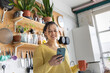 © ReeldealHD images - Young female student engaged with phone in cozy kitchen