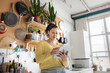 © ReeldealHD images - Young woman Using Tablet While Smiling in Cozy Kitchen