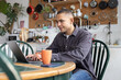 © ReeldealHD images - Young man working from home on his laptop in the kitchen
