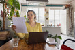 © ReeldealHD images - Young woman looking at finances at home with a laptop