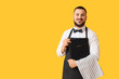 © Pixel-Shot - Male waiter with menu on yellow background
