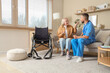 © Pixel-Shot - Mature woman talking to doctor on sofa at home