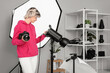 © Pixel-Shot - Beautiful young female photographer with professional camera and equipment working in studio