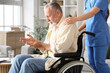 © Pixel-Shot - Senior man suffering from Parkinson syndrome in wheelchair with nurse at home