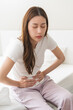 © KMPZZZ - Flatulence ulcer, asian young woman, girl hands in belly, stomach pain from food poisoning, abdominal pain and digestive problem, gastritis or diarrhoea. Abdomen inflammation, menstrual period people.