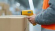 © Business Image - Moderne Logistik in Deutschland: Ein Arbeiter scannt Barcodes auf verpackten Paketen in einer Lagerhalle.