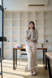 © Tj - Confident Asian business woman smiling in modern office