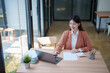 © Tj - Asian businesswoman smiling working on laptop in office