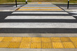 © mailcaroline - low angle view of a pedestrian crossing withtactile paving tiles. raised truncated domes with a detectable warning surface for visually impaired pedestrians. transportation background