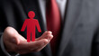 © photo for everything - Professional holds red figure, symbolizing human resource, employee care, and personnel management in business and corporate settings