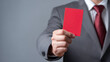 © photo for everything - Businessman in formal suit hold up a red card with serious expression, symbolizing rejection, warning, or a decisive halt to a situation
