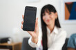 © Studio Marmellata - A woman holds a smartphone displaying an event app welcome message. The app invites users to connect with buyers and plan meetings for a large exhibition.