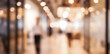 © birulaut - A blurred view of a modern shopping mall with warm lighting, featuring people walking and a vibrant atmosphere, capturing the essence of urban retail spaces.