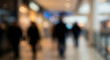 © birulaut - A blurred image capturing the busy atmosphere of a shopping mall with silhouettes of people walking in various directions, creating a sense of movement.
