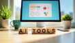 ©  VladaToday - Wooden block letters spelling ai tools on a modern desktop with computer screen in background for technology website banner and workspace hero image