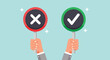 © Caroline Studio - Hands holding right and wrong signs for decision making.