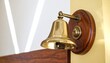 © Innovation - Polished brass bell on wooden mount