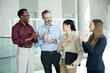 © Dejan - Happy business professionals applauding and recognizing a colleague for her great work and success in a modern office