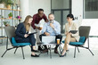 © Dejan - Diverse business people gathering around laptop, discussing ideas and collaborating on project in modern office lounge