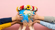 © Rubeka - Diverse group of people holding earth globe together decorated with flower crown representing global unity and environmental protection awareness