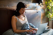 © Davor - Woman working on laptop in bed at home