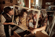 © Geber86 - Grandfather and father teaching child woodworking in workshop