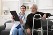 © New Africa - Care worker with clipboard talking to senior man indoors