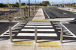 © Doublelee - Raised pedestrian crossing with tactile paving and bollards in a newly developed urban car park in Australia. Clear road markings, accessible design and empty parking space. Modern infrastructure