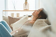 © buritora - A stylish Asian housewife relaxing on the living room sofa.