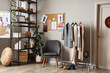 © Pixel-Shot - Interior of fashion designer's studio with armchair, clothes rack and pin board
