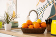 © Pixel-Shot - Wicker basket with lemons and oranges near sink on counter in kitchen