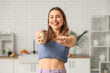 © Pixel-Shot - Happy smiling young woman pointing at chocolate ice cream in waffle cup at home