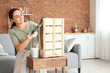 © Pixel-Shot - Young woman painting wooden box at home