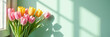 © OlgaNeuroArt - Pink and yellow tulips by a window with shadows on a mint green wall. Wide spring floral banner with copy space. Bright interior lifestyle background with morning sunlight
