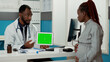 © DC Studio - Physician holding digital tablet with horizontal greenscreen at consultation with pregnant woman. Male doctor using blank chroma key with isolated mockup template and copyspace. Tripod shot.