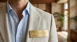 © Helen - Close-up of a man wearing a light beige blazer and blue shirt with a manager name tag