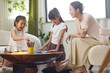 © Blue Jean Images - Mum watching daughters doing art homework