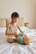 © Blue Jean Images - Girl dressing up her toy bear