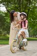© Blue Jean Images - Mother helps her daughter put on her protectors to get ready for a bike ride