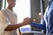 © Westend61 - Happy young man high fiving with colleague in a cafe