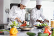 © DC Studio - Woman chef in uniform slicing a bell pepper in professional kitchen, using fresh produce and kitchen tools to create a delicious dish. Culinary expert prepared ingredients on the stove.