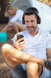 © auremar - man using mp3 player at campsite