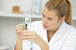 © auremar - woman doctor holding magnifying glass for analysis test tube