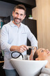 © auremar - happy young woman with hairdresser washing head