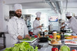 © DC Studio - In a professional kitchen, male cook preparing gourmet meals by using cutting boards and chopping ingredients. Chef cooking with fresh produce, doing food prep for tasty dishes, gastronomy.