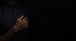 © pngking - Male hand softly touching chest with dark backdrop and wide copy space illustrating intimate emotion and communicative openness