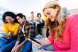 © Xavier Lorenzo - Diverse young student friends using smart phones together outdoors. Social media conceopt