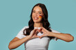 © Home-stock - Positive young woman expressing her pride for her country, making heart shape with her hands and posing with flag of Germany over blue background