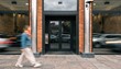 © Justlight - Medium shot of a standalone subprime finance office entrance with clear signage the foreground pedestrian and background vehicles blurred to emphasize the location.