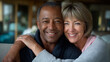 © Nataliya - Defocused unrecognizable mature multiethnic couple laughing and embracing in a cozy home living room, authentic moment of love and affection, senior lifestyle, togetherness